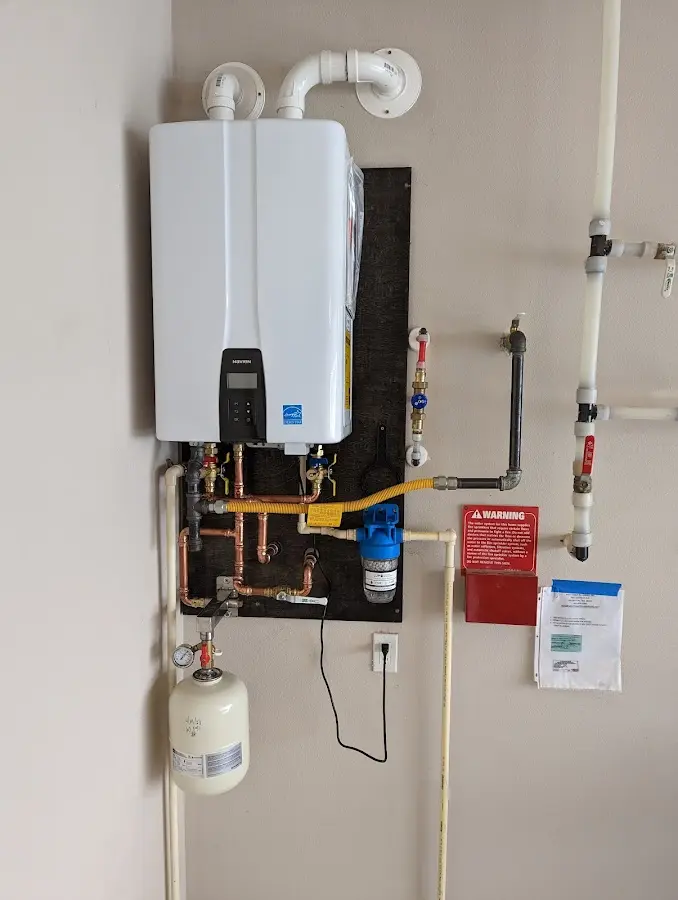 Professional plumber installing copper piping in a Winterport home